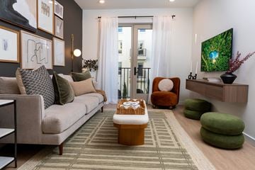 Montclair apartment for rent - A living room with a couch, chair, ottoman, and a painting on the wall.