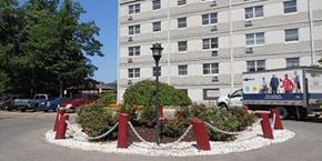 Lorain apartment for rent - a roundabout with red and white barriers in front of a building
