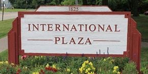 Lorain apartment for rent - a sign for international plaza in front of a garden