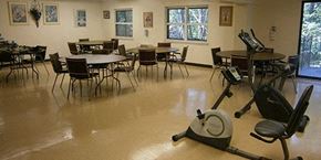 Elyria apartment for rent - a gym room with tables and chairs and a treadmill