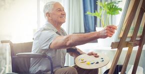 Anaheim apartment for rent - an older man sitting in a wheelchair painting on his art easel