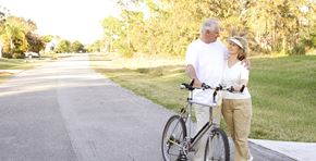 Anaheim apartment for rent - a man and a woman walking a bike down a sidewalk