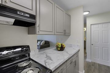 Lynnwood apartment for rent - a kitchen with white cabinets and a stove and a sink