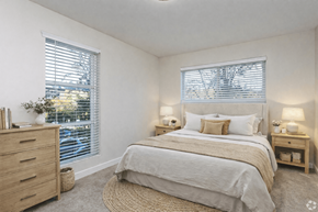 Seattle apartment for rent - A bedroom with a large bed, a dresser, and two nightstands with lamps.