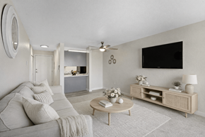 Lynnwood apartment for rent - A living room with a grey couch, a wooden coffee table, and a flat screen TV mounted on the wall.