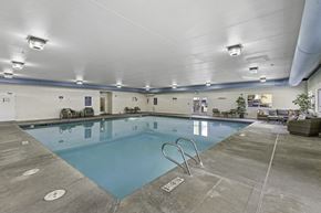 Everett apartment for rent - a swimming pool with chairs and tables around it  at Camelot Apartment Homes, Everett, WA, 98204