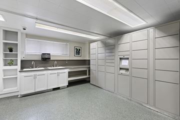 Seattle apartment for rent - A clean, white-walled office kitchen with a counter and cabinets.