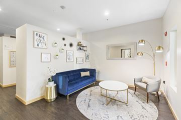 Seattle apartment for rent - a living room with a blue couch and a round table
