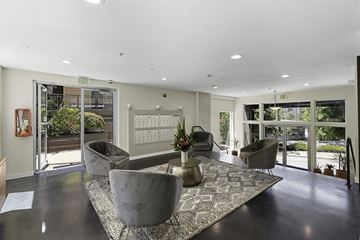 Seattle apartment for rent - A spacious living room with grey chairs and a patterned rug.