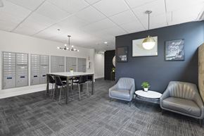 Tacoma apartment for rent - Cozy Lobby Area with a table and chairs and convenient mailboxes on the wall at Villaggio Apartment Homes, Tacoma, 98402