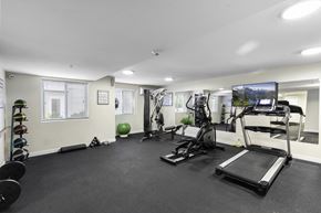 Everett apartment for rent - a gym with exercise equipment and a flat screen tv at West Mall Place Apartment Homes, Everett, WA