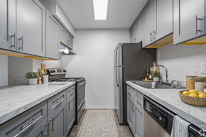 Everett apartment for rent - A kitchen with a black refrigerator and grey cabinets.