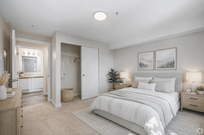 Everett apartment for rent - A well-lit bedroom with a large bed and a vanity table.