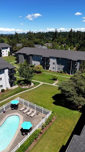 Edmonds apartment for rent - A pool with a hot tub and a white fence in front of a building.