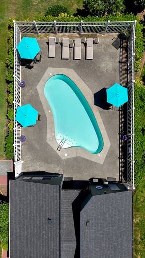 Edmonds apartment for rent - A pool surrounded by a fence and umbrellas.