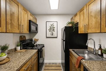 Edmonds apartment for rent - A kitchen with wooden cabinets and a black refrigerator.