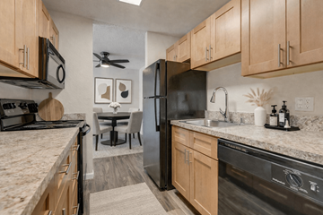 Edmonds apartment for rent - A kitchen with a black refrigerator and wooden cabinets.