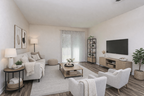 Edmonds apartment for rent - A living room with a white couch, a wooden coffee table, and a flat-screen TV mounted on the wall.