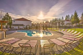 Lynnwood apartment for rent - Glistening Swimming Pool at Sunset with lounge chairs and Meticulous Landscaping at Pinewood Square Apartment Homes, Lynnwood, WA
