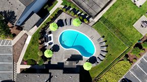 Lynnwood apartment for rent - An aerial view of a pool surrounded by a grassy area and a parking lot.