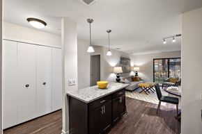 Northville apartment for rent - A kitchen with dark wood cabinets and a granite countertop at MainCentre, Northville