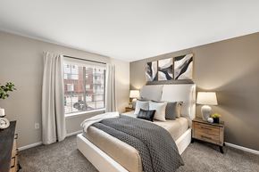 Novi apartment for rent - A bedroom with a large bed and a window with white curtains.