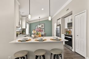 West Bloomfield apartment for rent - A kitchen with a white counter and three stools.