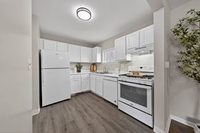 Novi apartment for rent - A kitchen with white appliances and wooden floors.
