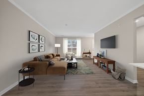 Canton apartment for rent - A living room with a brown couch and a television on the wall.