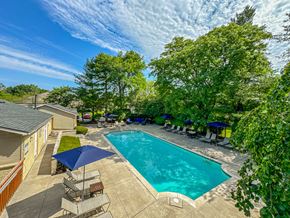 West Bloomfield apartment for rent - Pool and patio with chairs and umbrellas at Amberly Apartments, West Bloomfield, 48322