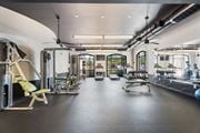 Fayetteville apartment for rent - A gym with a variety of equipment including a rowing machine, a bench press, and a leg press at The Villagio Apartments, Fayetteville, 28303