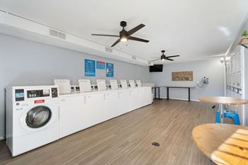 A laundromat with a row of washers and dryers.