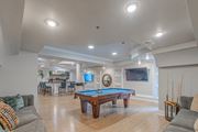 Woodbridge apartment for rent - A pool table in the middle of a room with a TV and a bar.