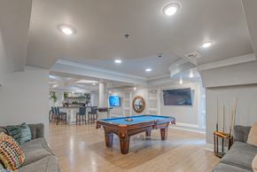 Woodbridge apartment for rent - A pool table in the middle of a room with a TV and a bar.