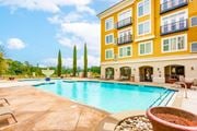 Fayetteville apartment for rent - A yellow building with a blue pool in front at The Villagio Apartments, Fayetteville, NC, 28303