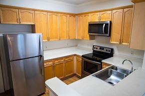 Orlando apartment for rent - A kitchen with wooden cabinets and a stainless steel refrigerator.