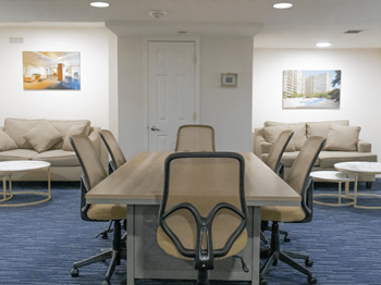 A conference room with a table and chairs and a couch 