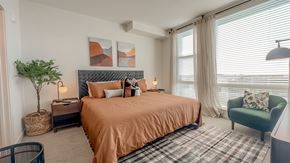 Herndon apartment for rent - a bedroom with a bed and a chair and a window at Makers Rise, Virginia, 20171