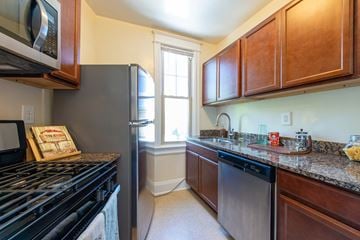 Washington apartment for rent - A kitchen with a black stove top oven and a black dishwasher.