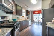 Herndon apartment for rent - A modern kitchen with dark wood cabinets and granite countertops.