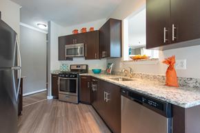 Herndon apartment for rent - A kitchen with dark brown cabinets and stainless steel appliances.