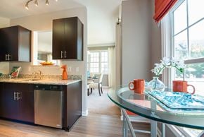 Herndon apartment for rent - A modern kitchen with a glass table and stainless steel appliances.