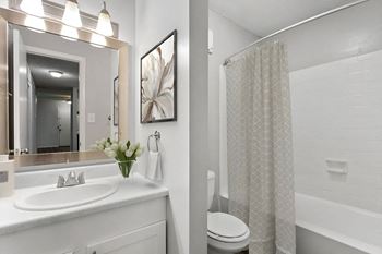 A white bathroom with a shower and a sink