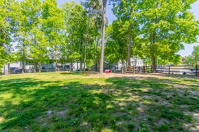 Burlington apartment for rent - A grassy area with trees and a fence in the background at West Pointe Apartments, Burlington, North Carolina