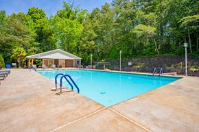 Burlington apartment for rent - A large swimming pool surrounded by trees and a small building at West Pointe Apartments, North Carolina