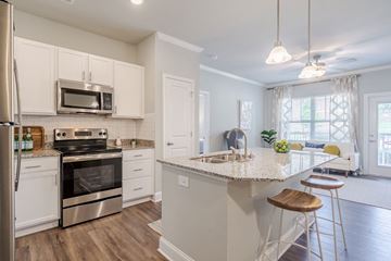 Pittsborro apartment for rent - A kitchen with white cabinets and a stainless steel refrigerator.