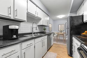 Burlington apartment for rent - a kitchen with white cabinets and a sink and a refrigerator at West Pointe Apartments, Burlington, 27215