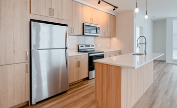 A kitchen with stainless steel appliances and a white counter top