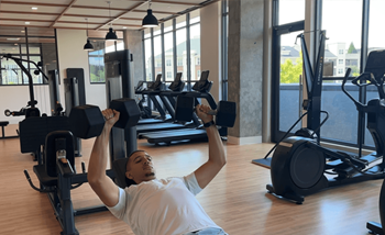 A man exercising in a gym with weights