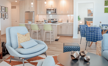 A living room and kitchen with blue chairs and a table